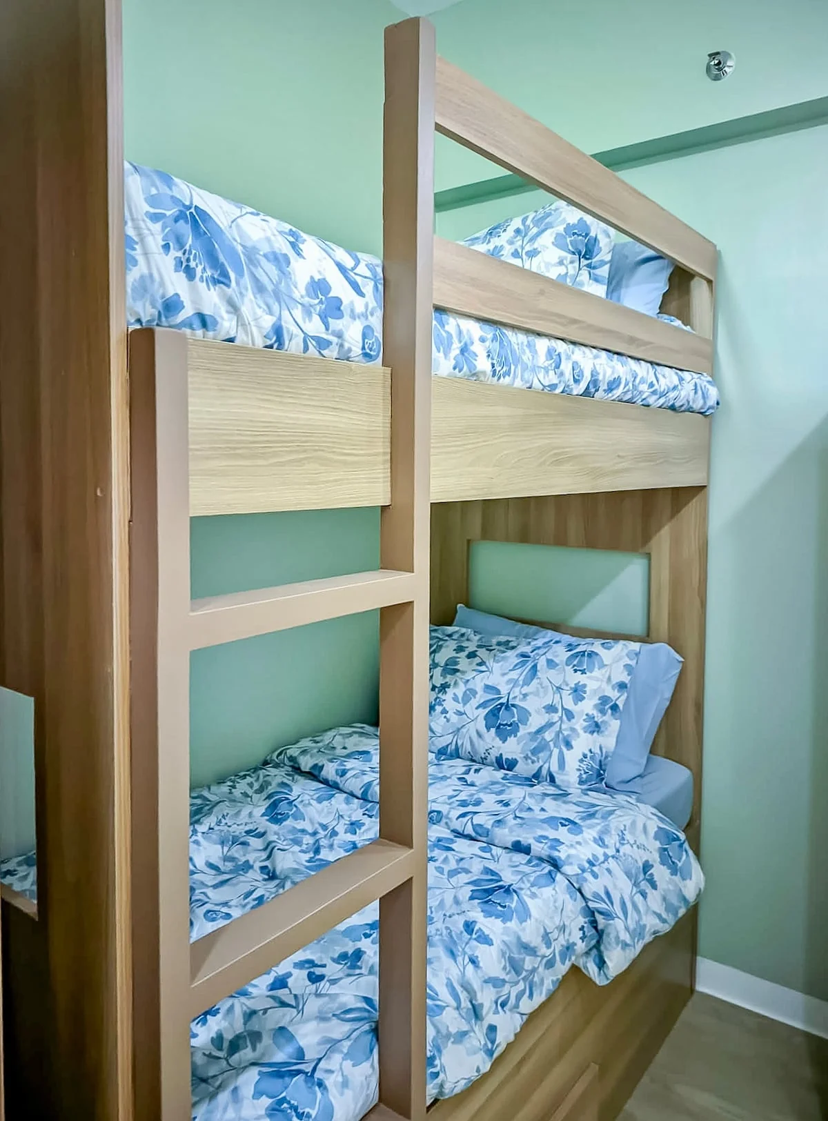 Wooden bunk beds with blue and white floral bedding
